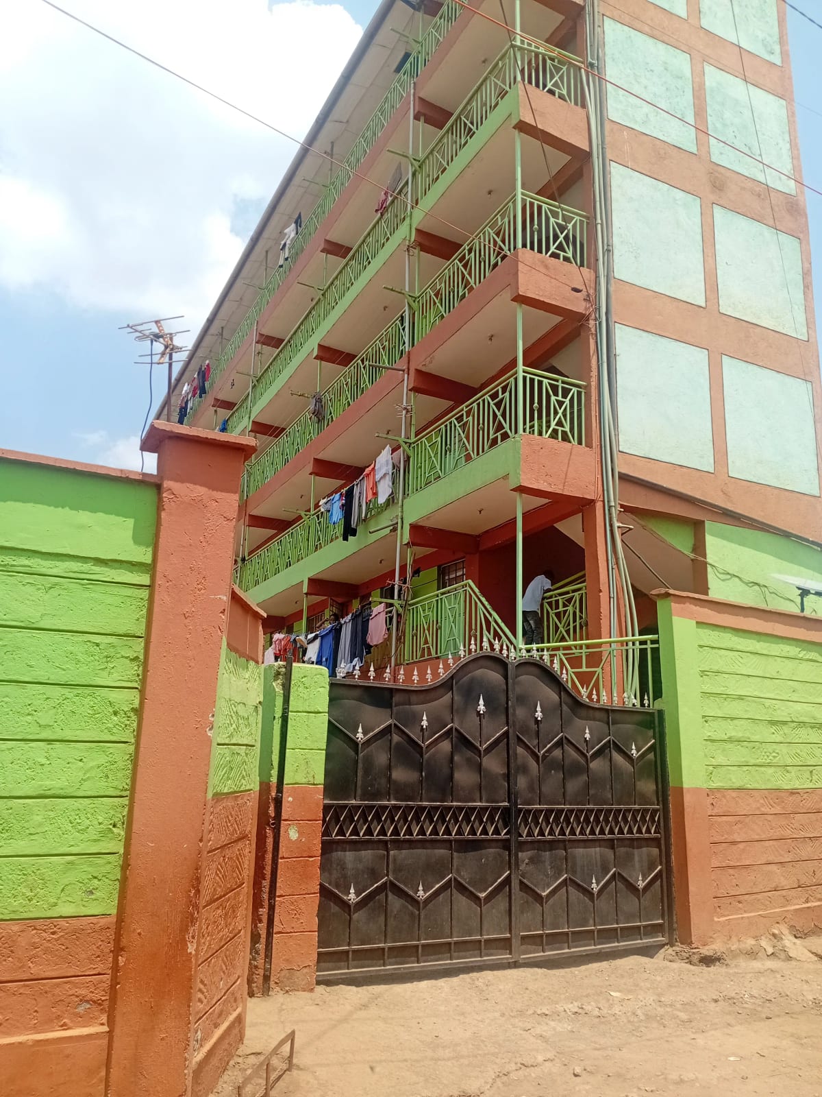 Multi-story residential building with metal gate entrance
