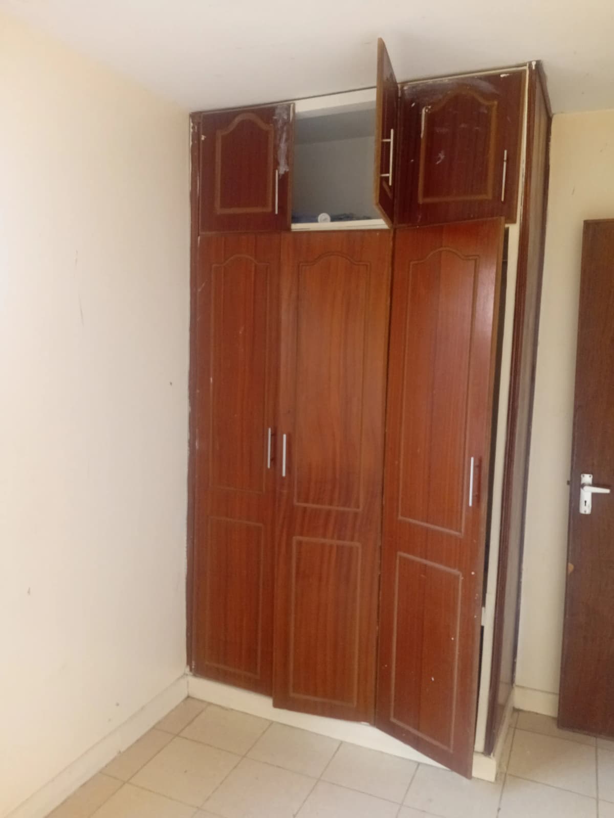Bedroom with large built-in wooden wardrobe and mirror