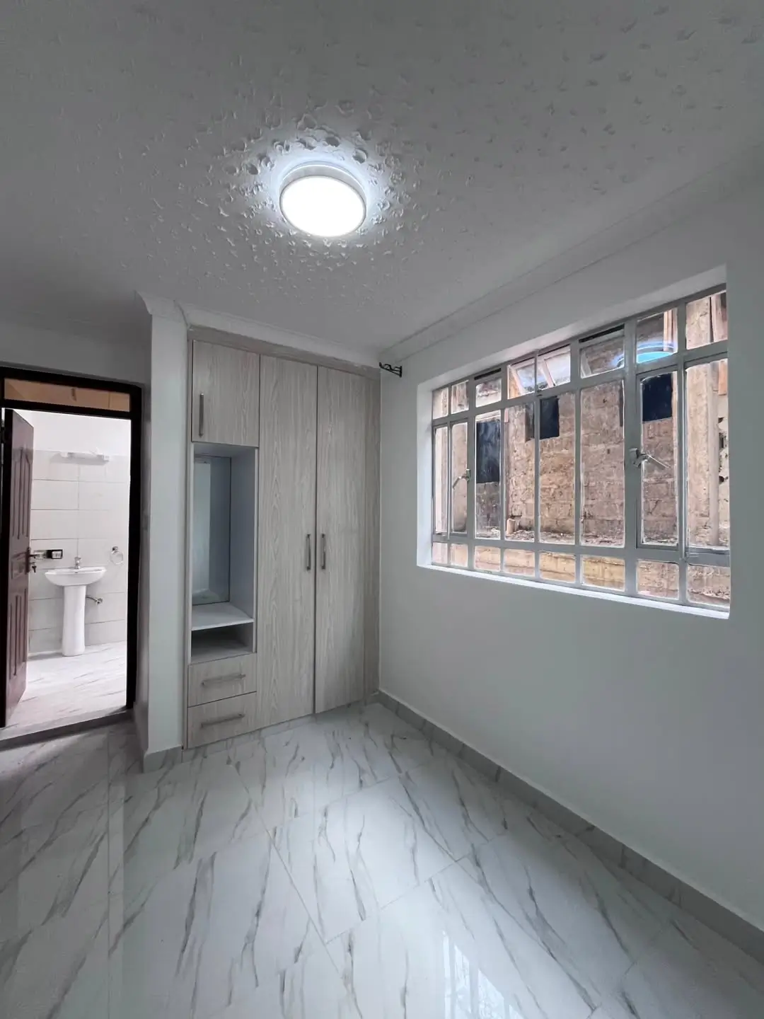 Bright bedroom with en-suite bathroom door visible