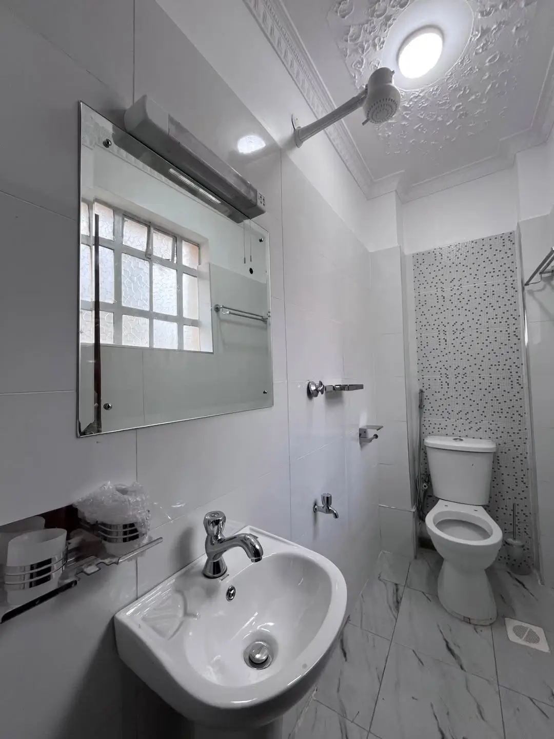 Clean bathroom with sink, toilet, and shower enclosure