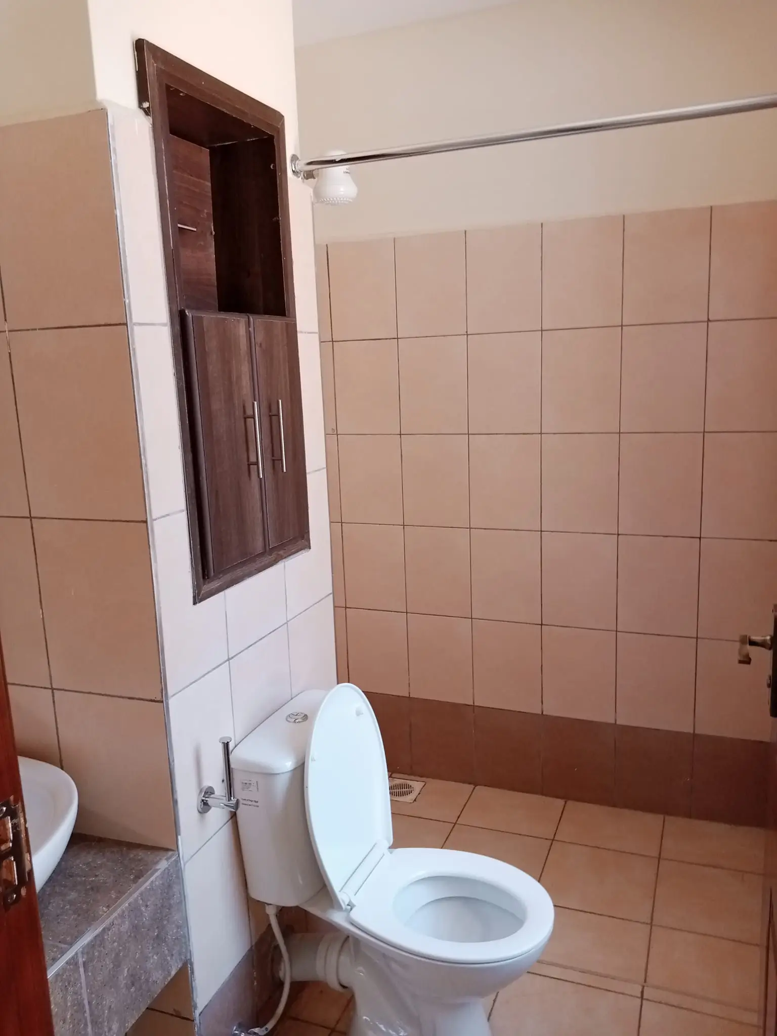 Bathroom with toilet, sink, tiled walls, small window