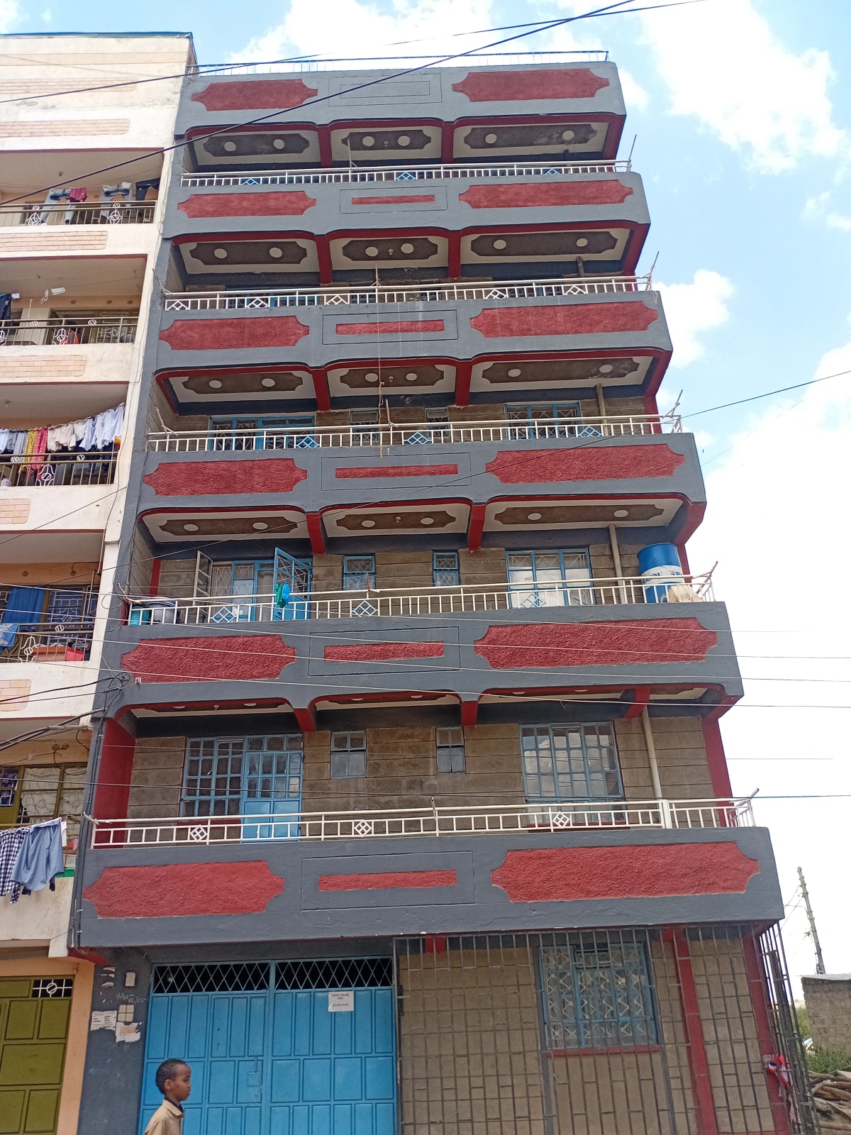 Multi-story residential building facade with red signage panels