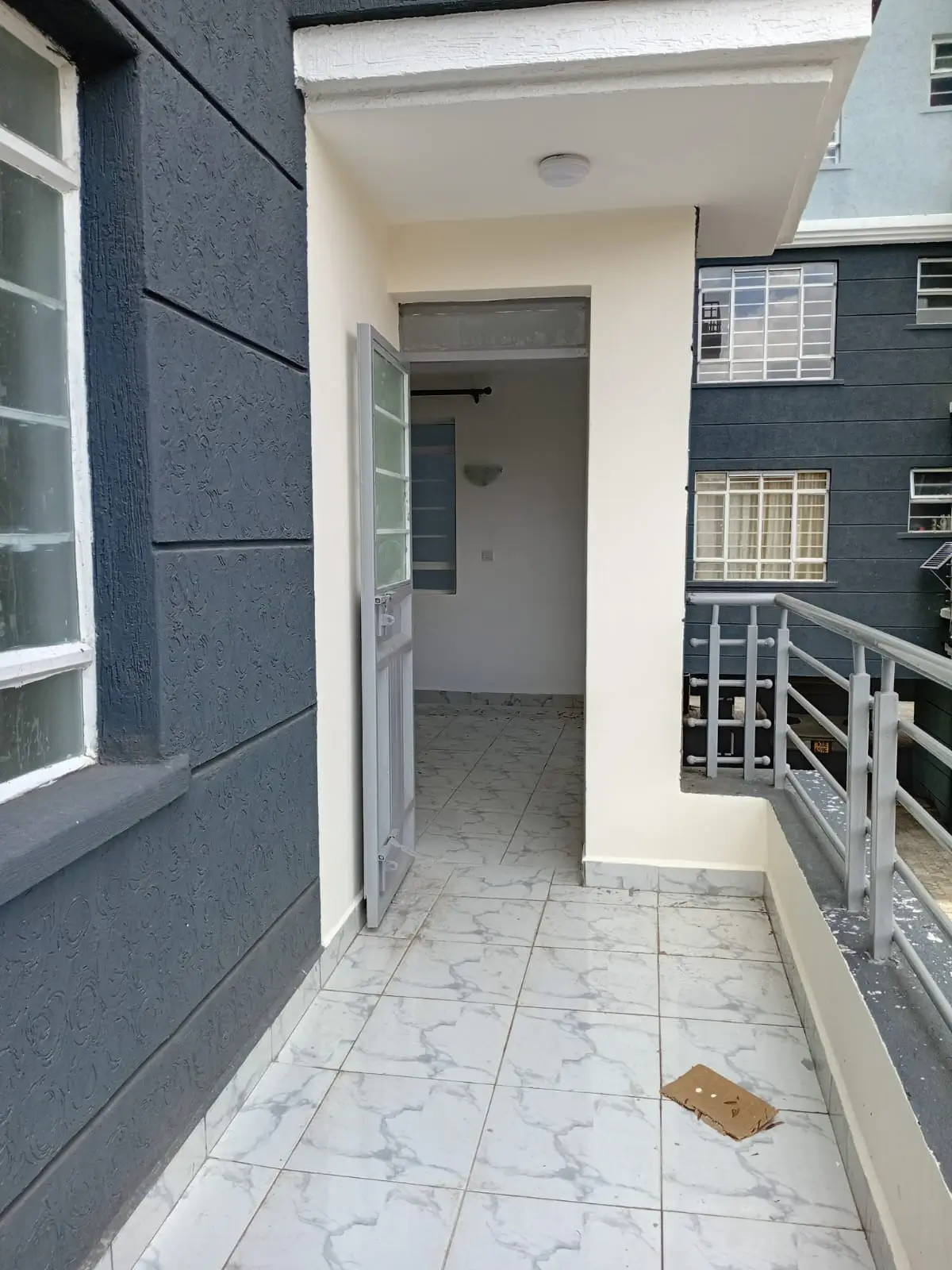 Covered terrace with marble tile flooring and metal railing