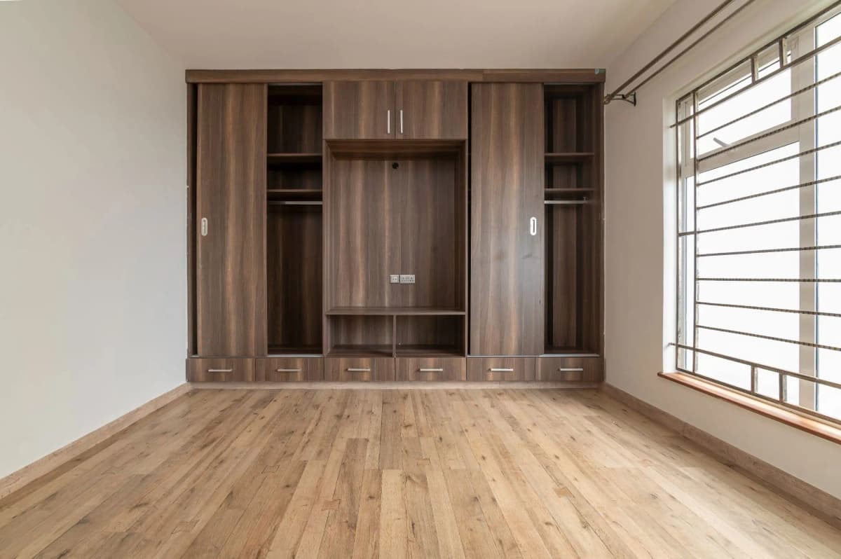 Spacious bedroom with built-in wooden wardrobe and natural light
