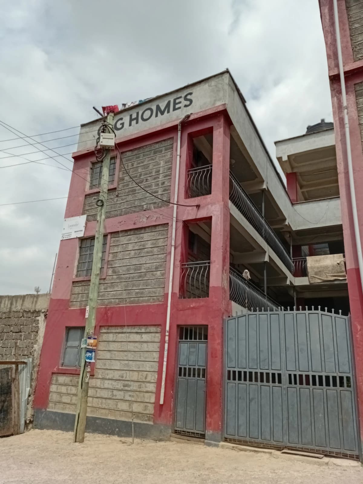 Red and stone multi-story residential building with metal gate entrance