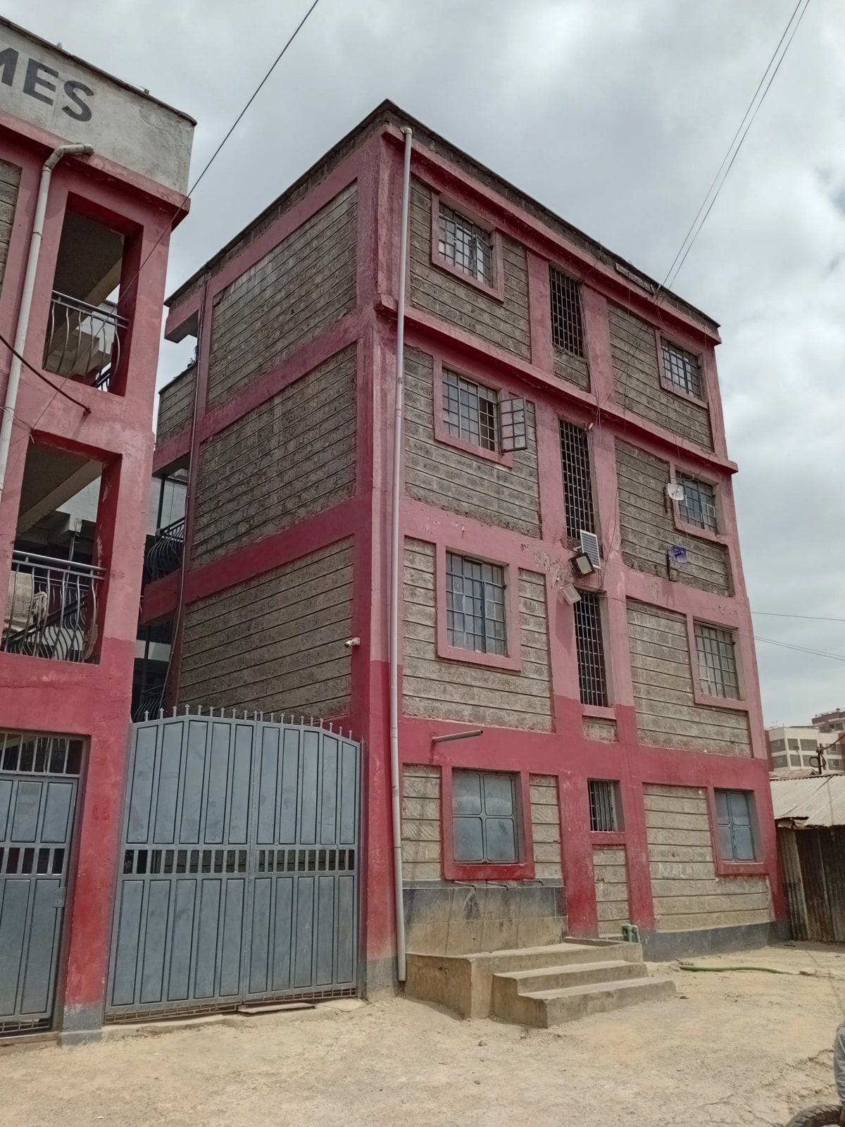 Red and cream multi-story residential building facade with garage entrance