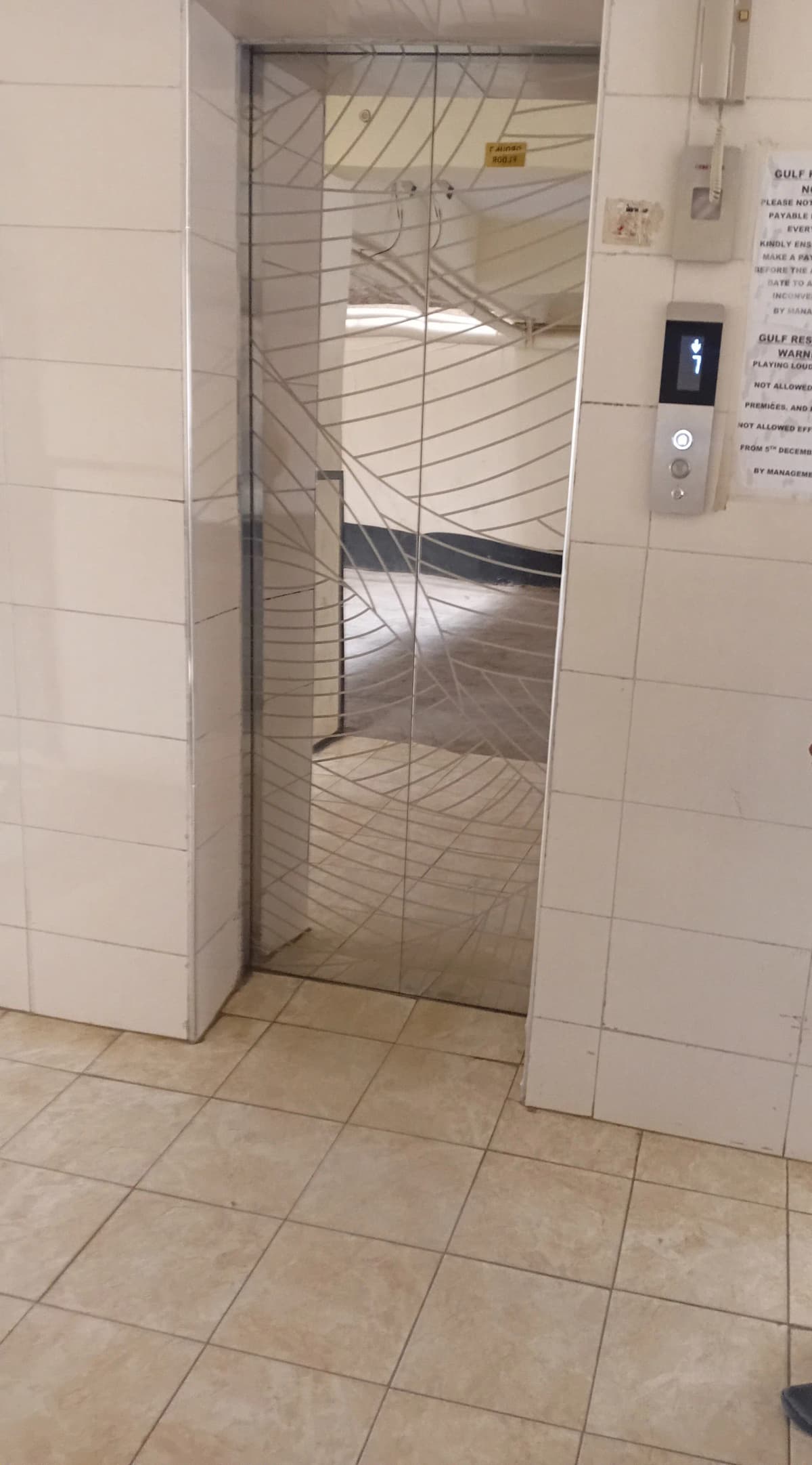 Building lift lobby with tiled flooring and metal gate doors