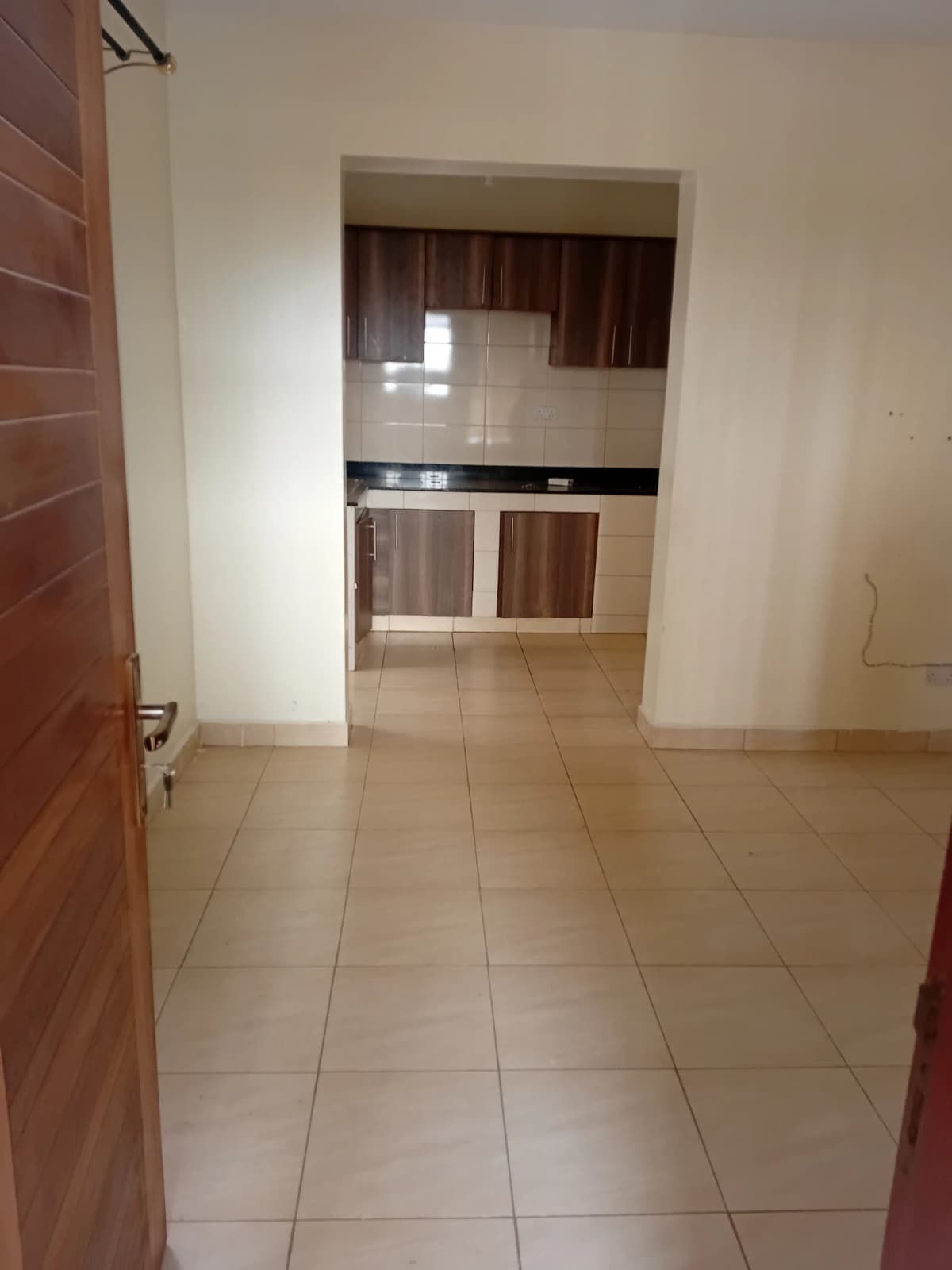 Open-plan kitchen with brown cabinetry and tiled flooring