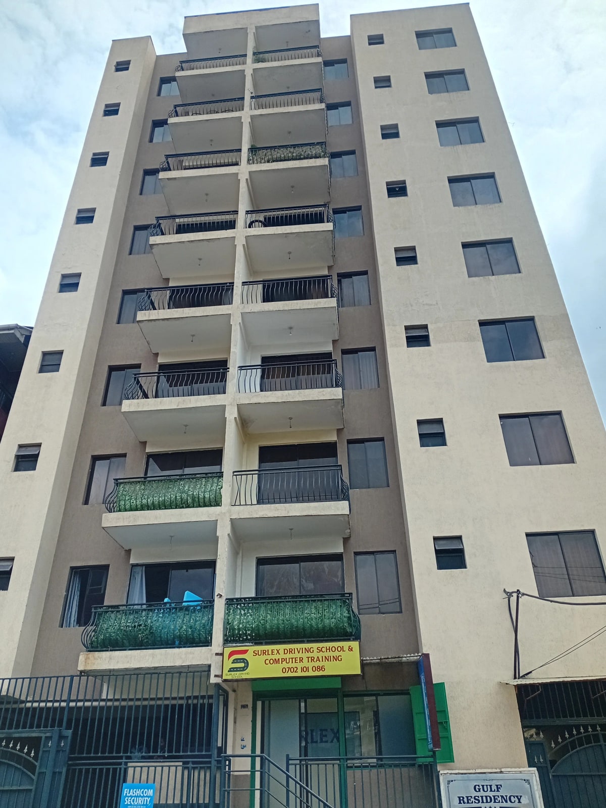 Multi-story residential apartment building with balconies and ground-floor commercial space