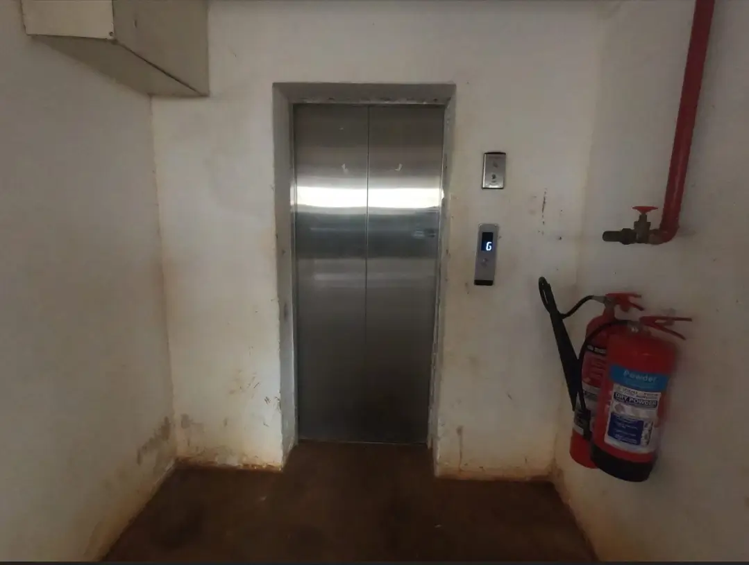 Building elevator lobby with fire extinguisher and utility pipe