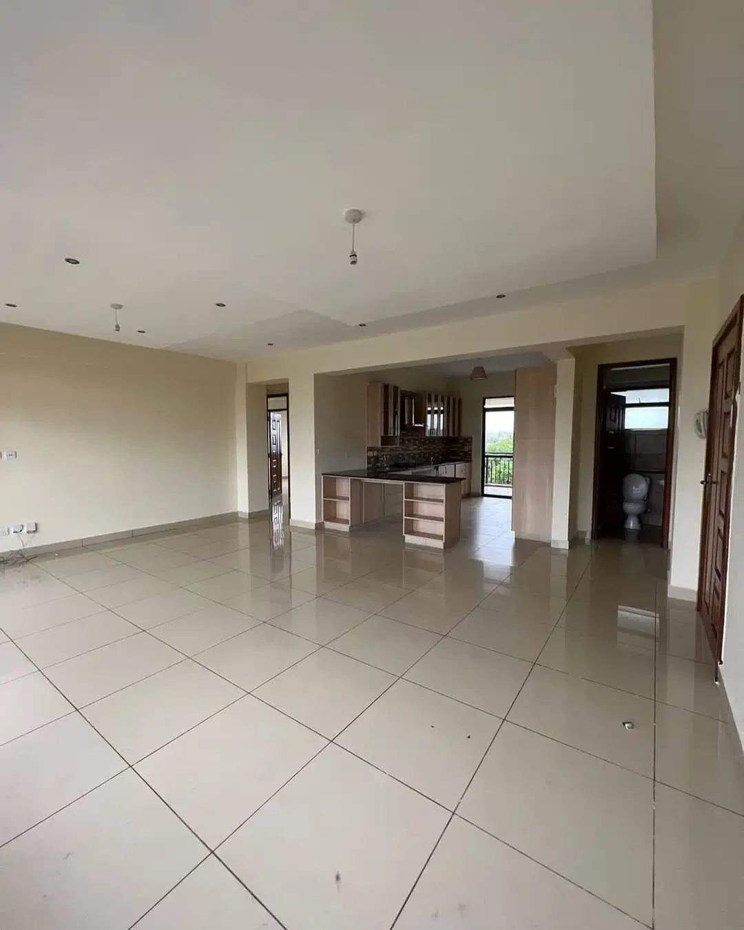 Open-plan living area with kitchen visible in background