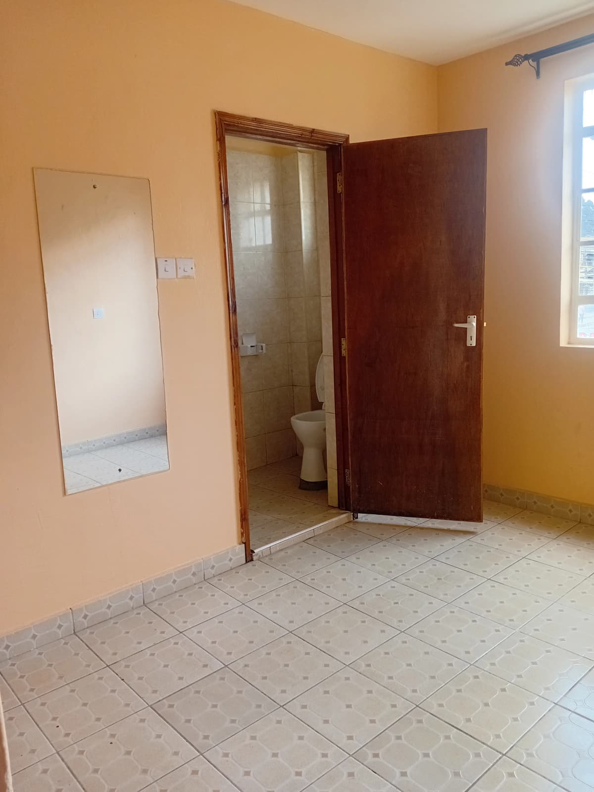 Spacious bedroom with en-suite bathroom entrance visible