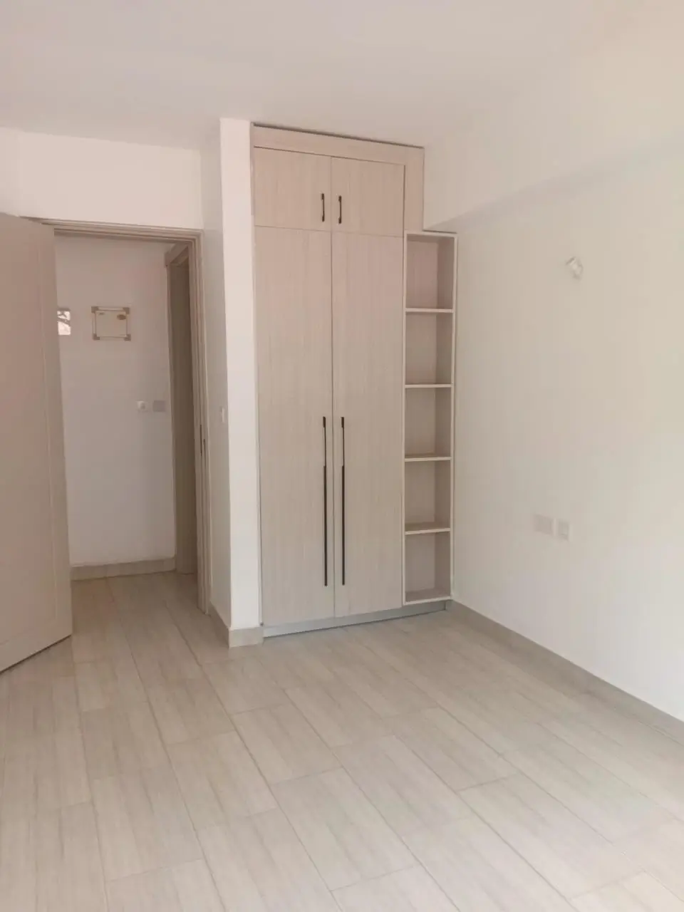 Spacious bedroom with built-in wardrobe and shelving