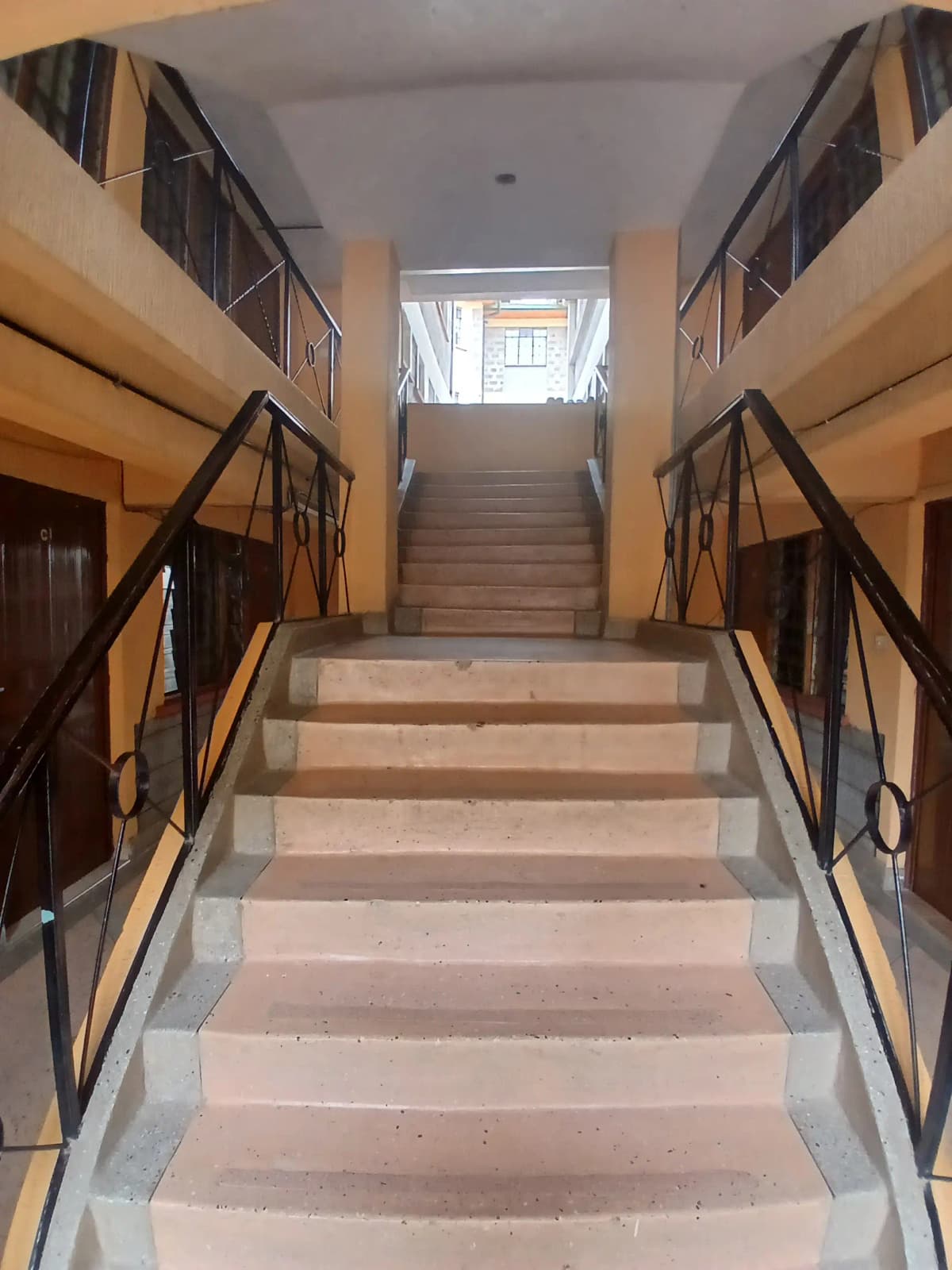 Multi-story stairwell with handrails and residential doors