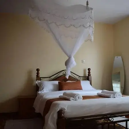 Master bedroom with four-poster bed and sheer canopy draping
