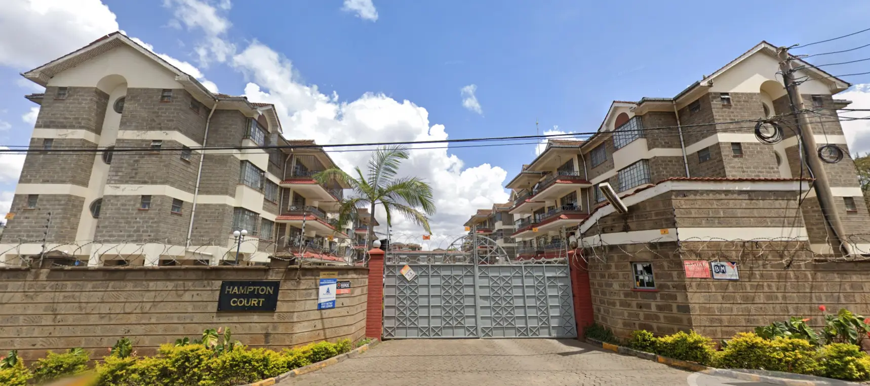 Hampton Court apartment complex with gated entrance and landscaping