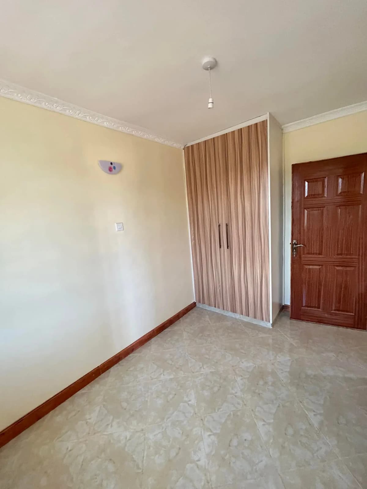 Unfurnished bedroom with cream walls and wooden door