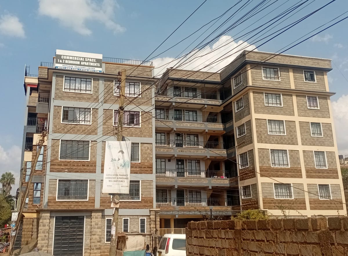 Multi-story residential building facade with balconies and ground level garage