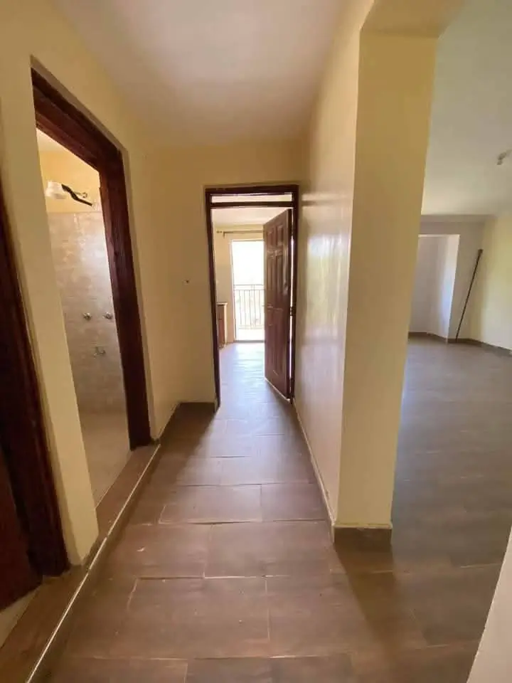Long hallway with multiple doors and ceramic flooring