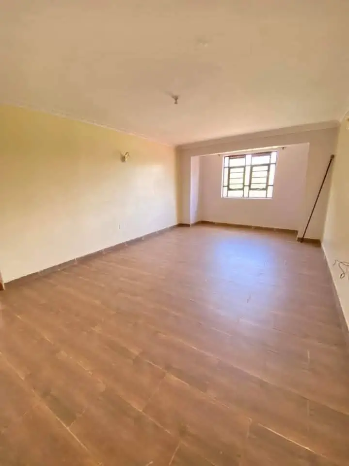 Empty living room with wooden flooring and barred window