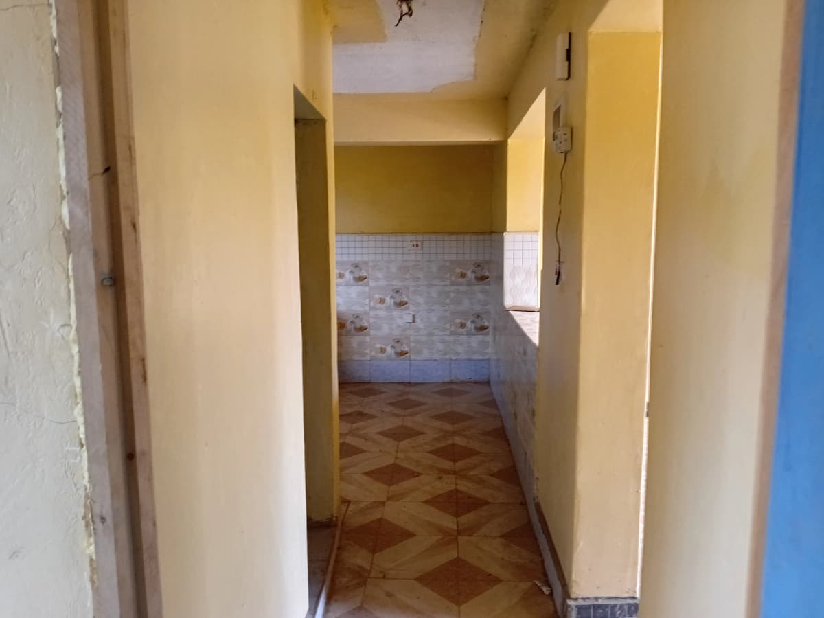 Narrow hallway with geometric tile flooring and yellow walls