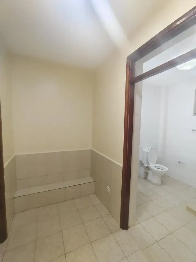 Compact utility storage room with tiled flooring and shelving