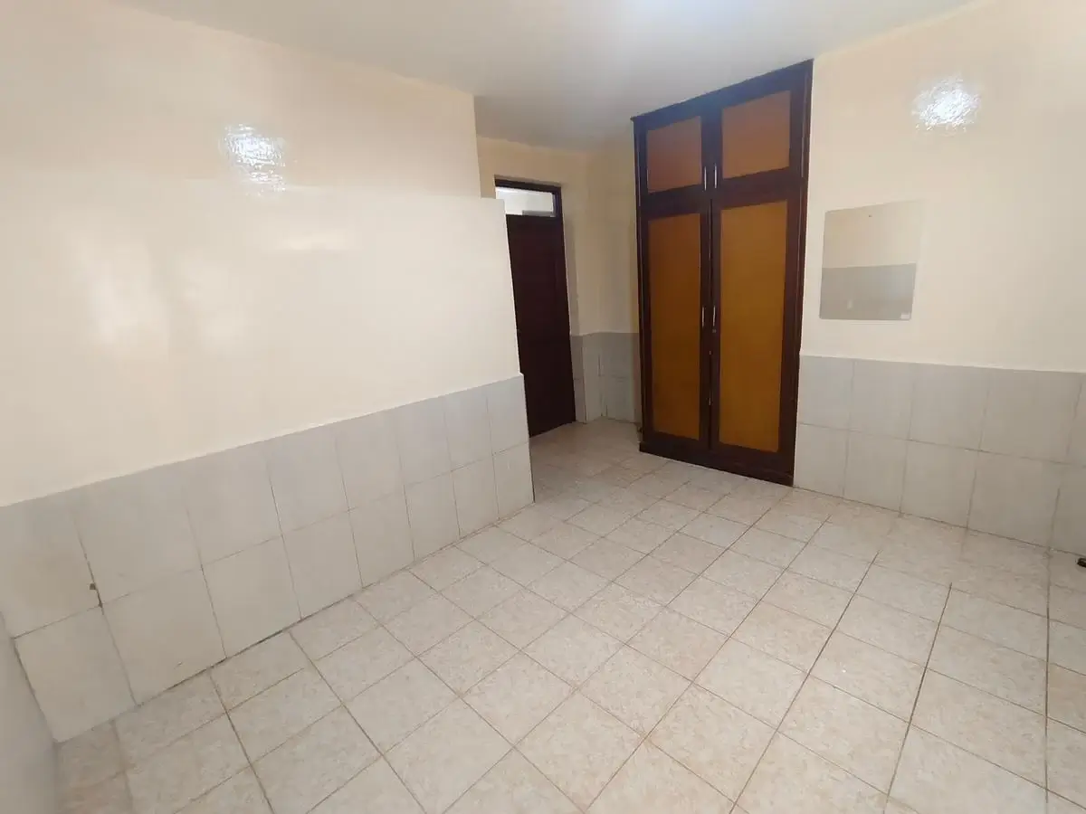 Empty corridor with tiled floors and wooden doors