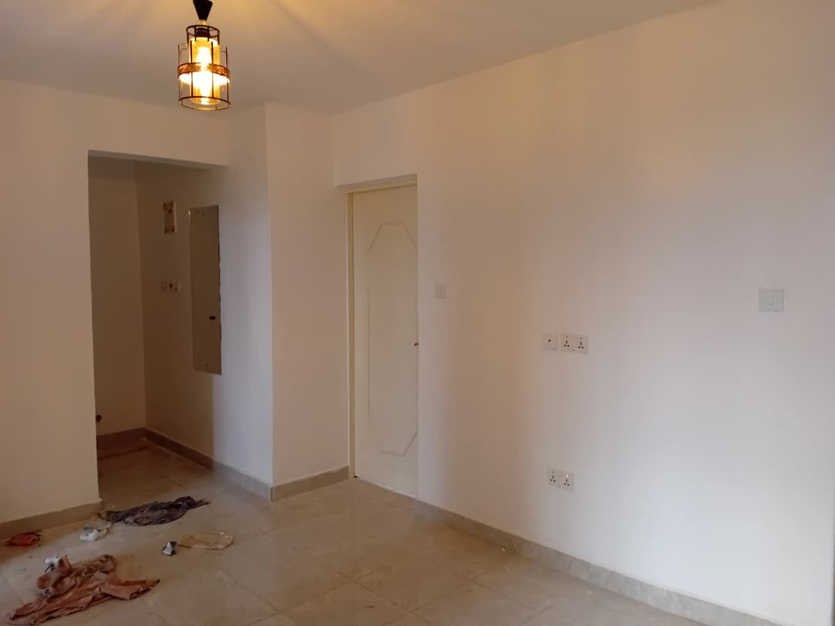 Empty living space with multiple doorways, minimal fixtures