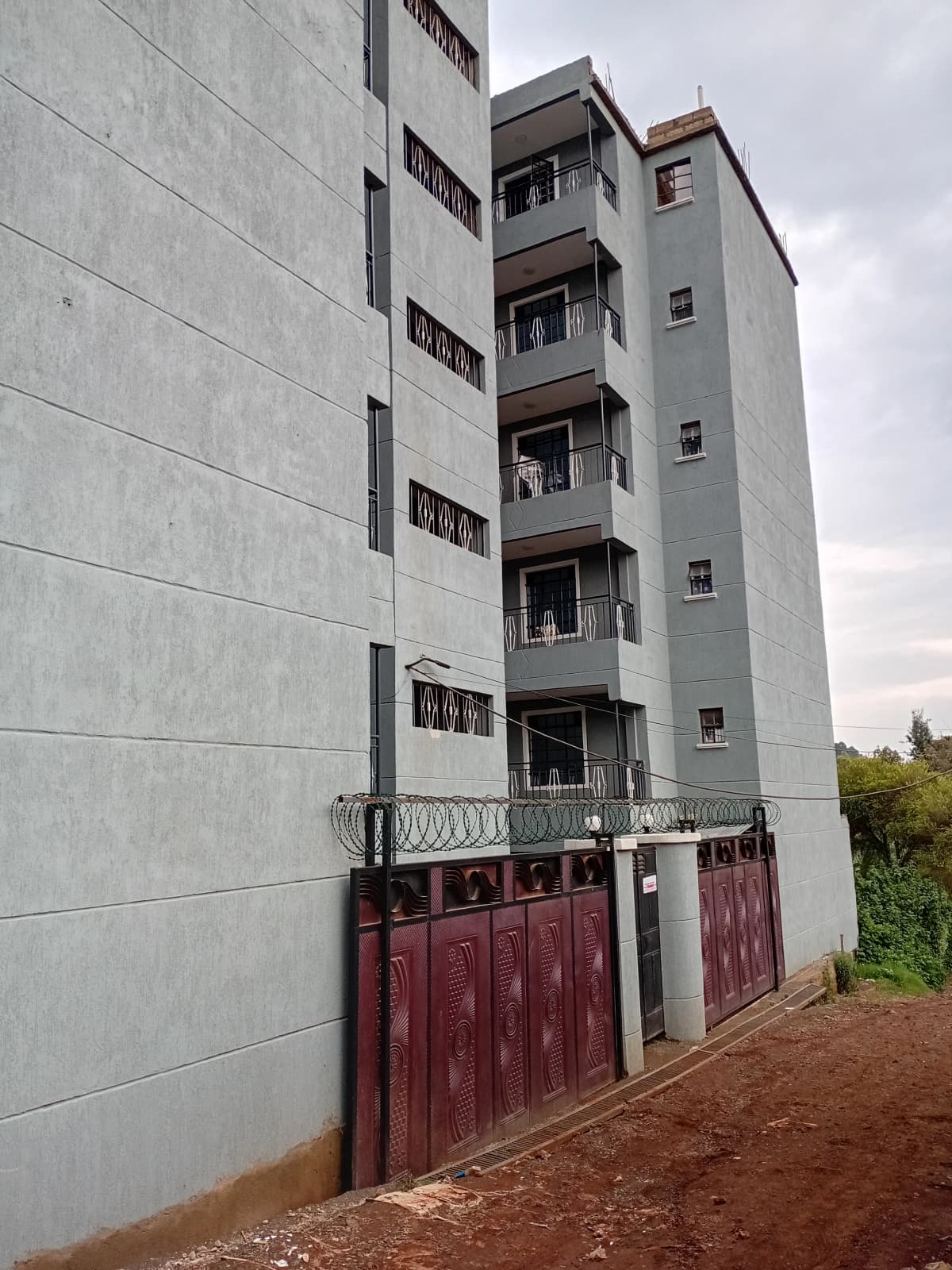 Multi-story residential building facade with balconies and gate