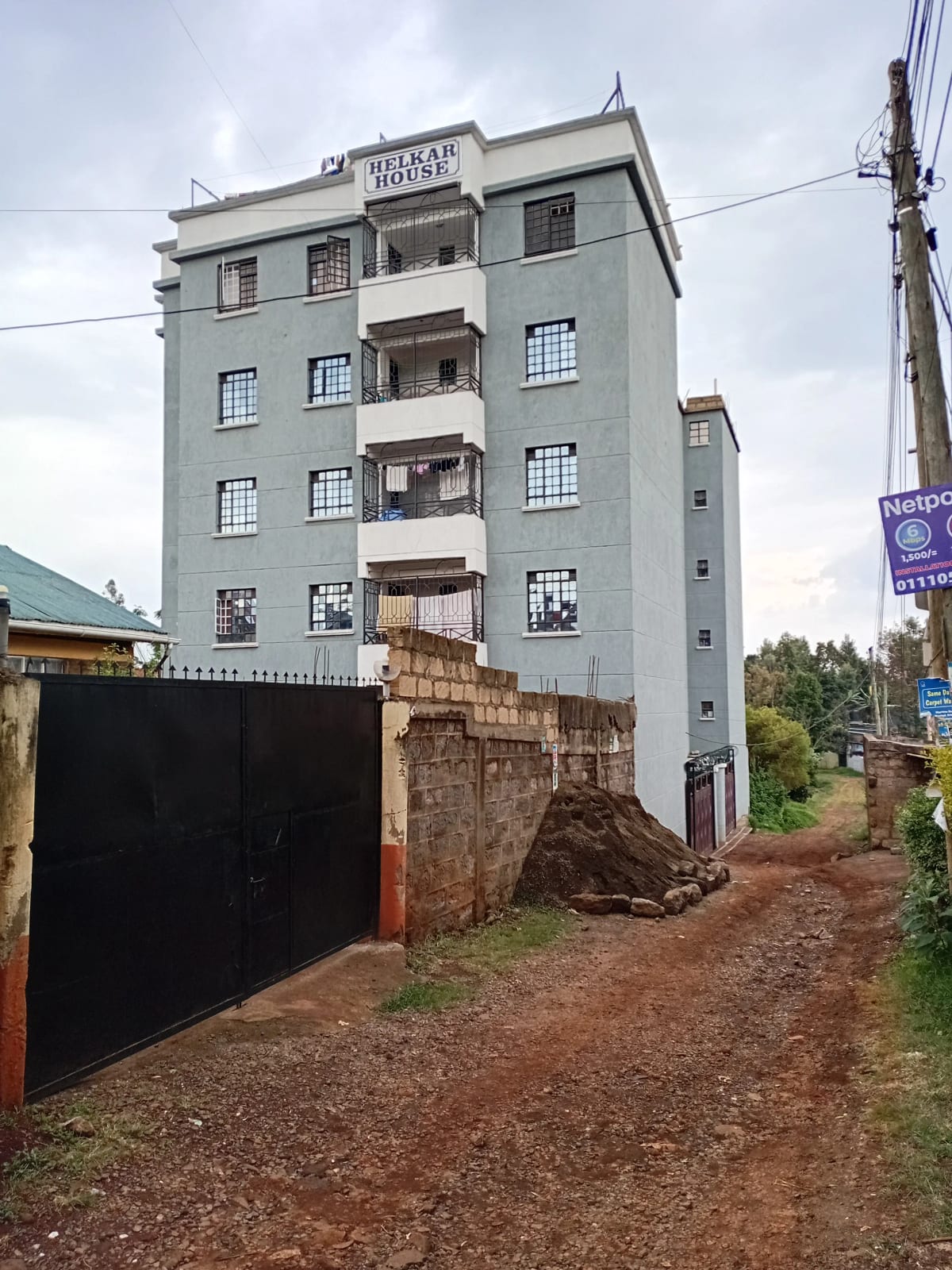 Multi-story residential building with black metal gate entrance