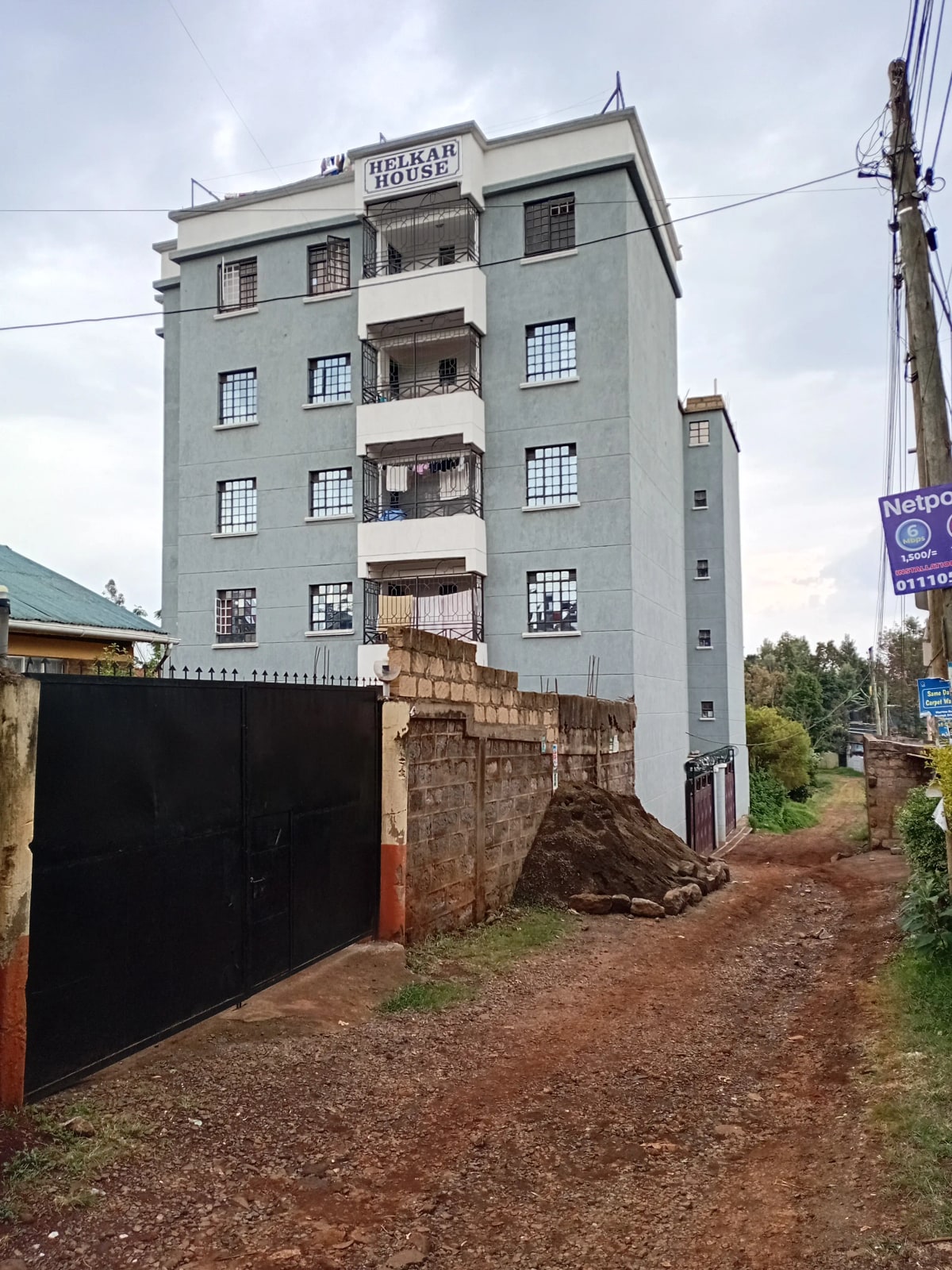 Multi-story residential building with black metal gate entrance