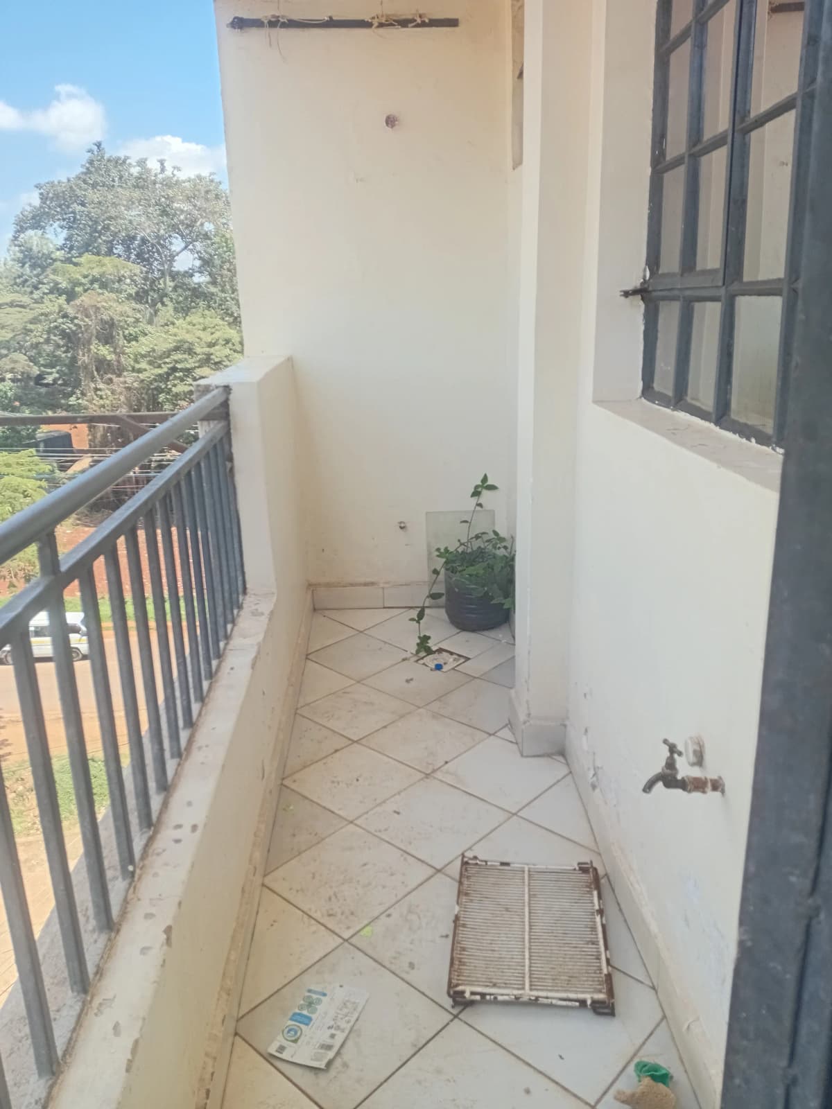 Narrow balcony with metal railing and tiled flooring