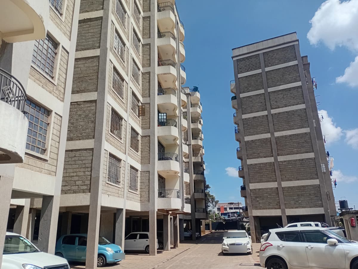 Multi-story residential complex with ground-floor parking bays