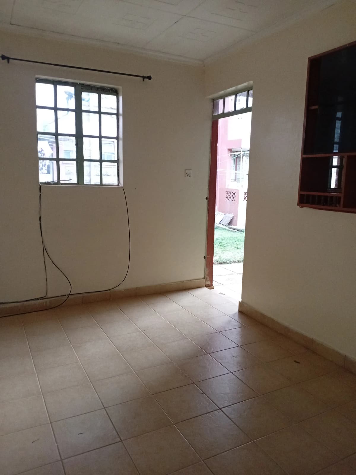 Empty living room with tiled floors and natural light