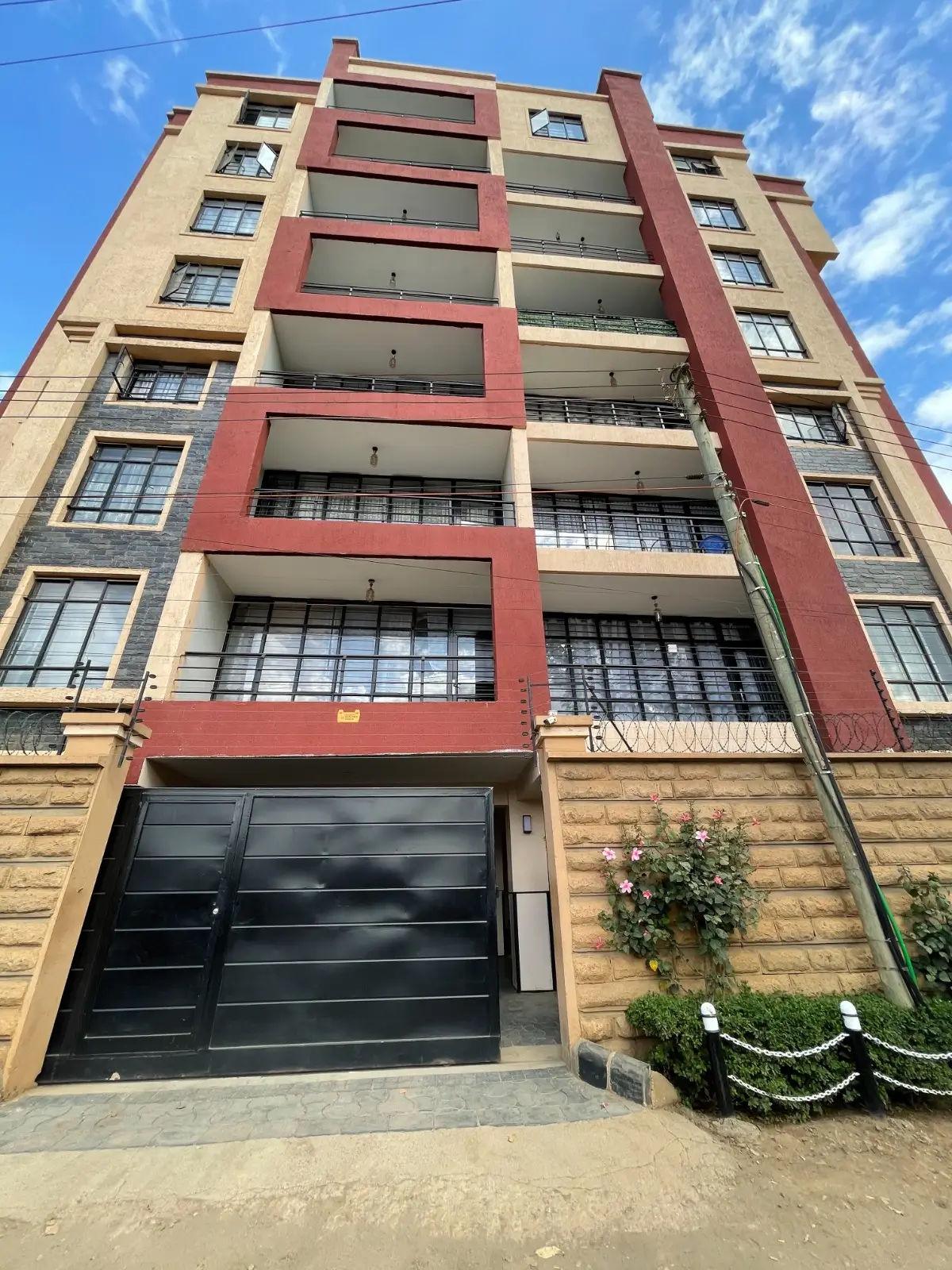 Multi-story residential building with red accent stripes and garage