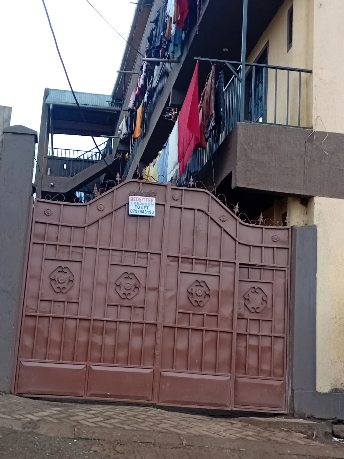 Brown ornamental metal gate with compound entrance