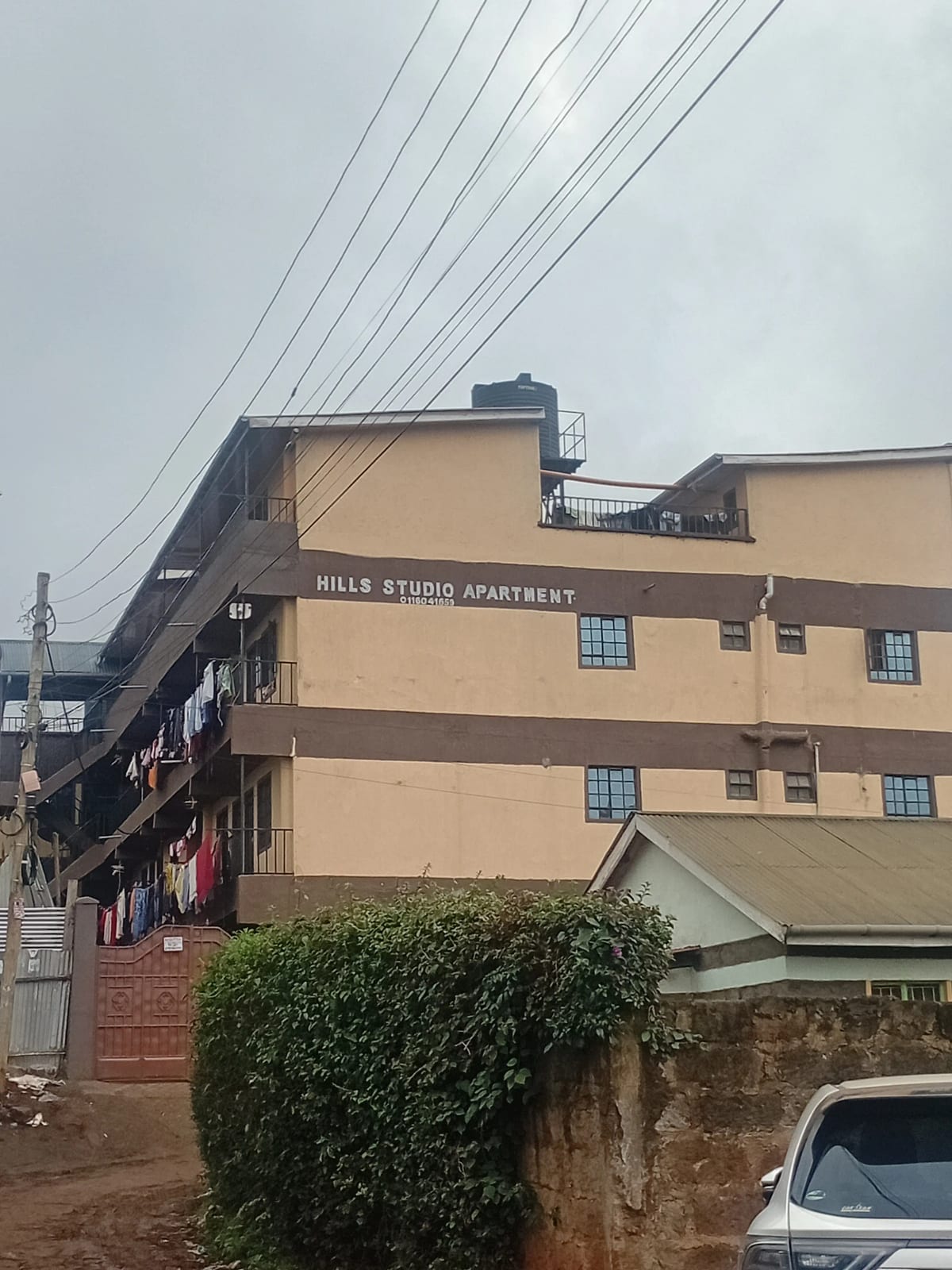 Multi-story apartment building facade with signage and compound grounds