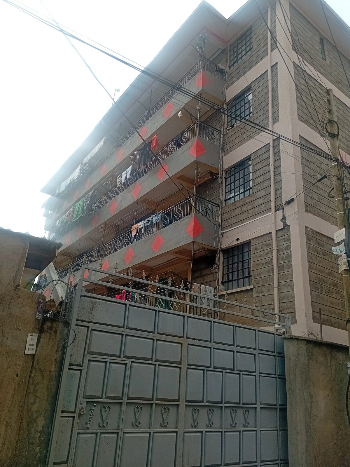 Multi-story residential building with metal gate entrance