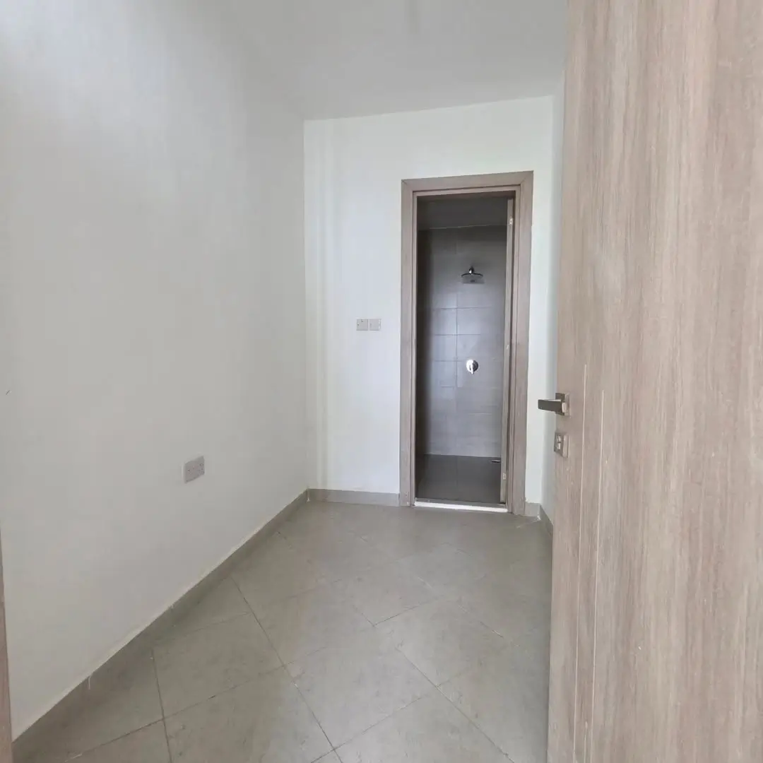 Bright corridor with bathroom entrance and wooden door