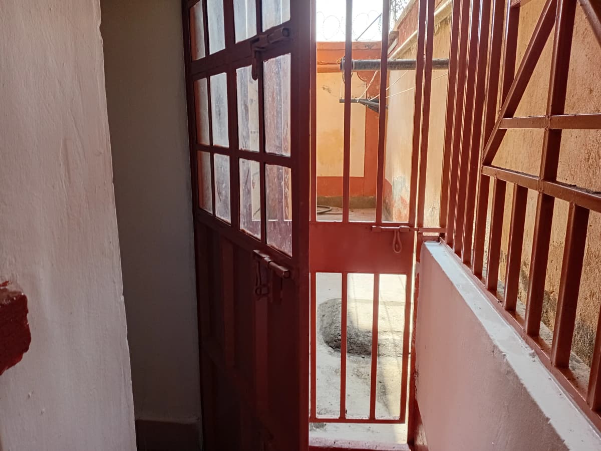 Narrow balcony with wooden railings and red door access