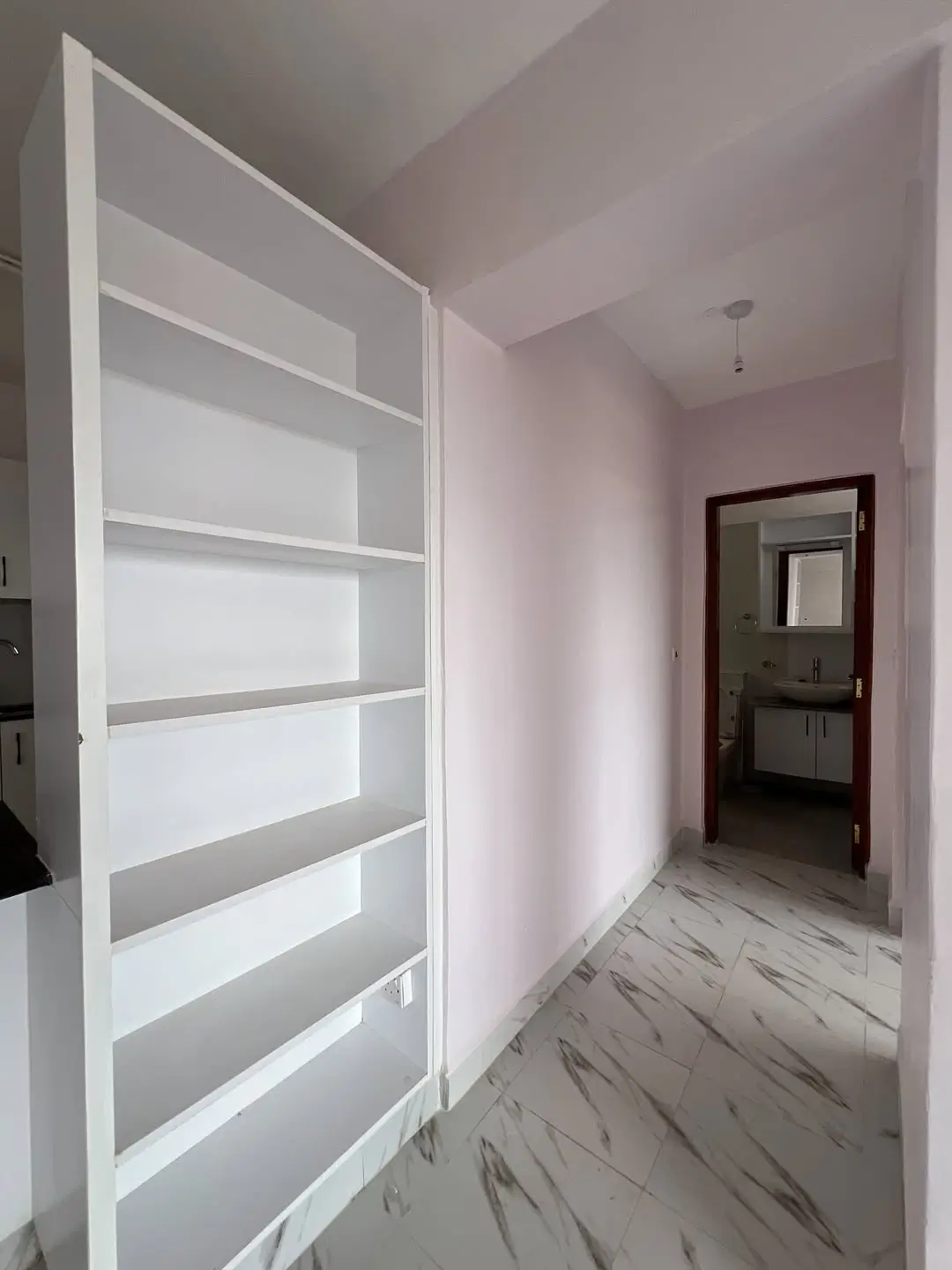 Modern hallway with built-in storage shelving and marble flooring
