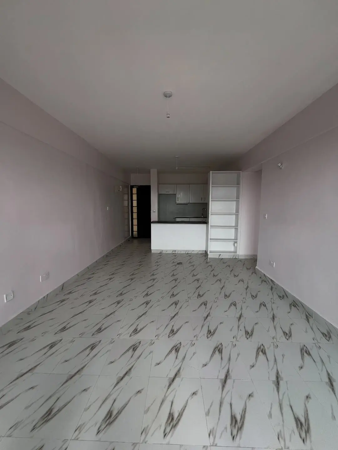 Open-plan living area with integrated kitchen visible in background