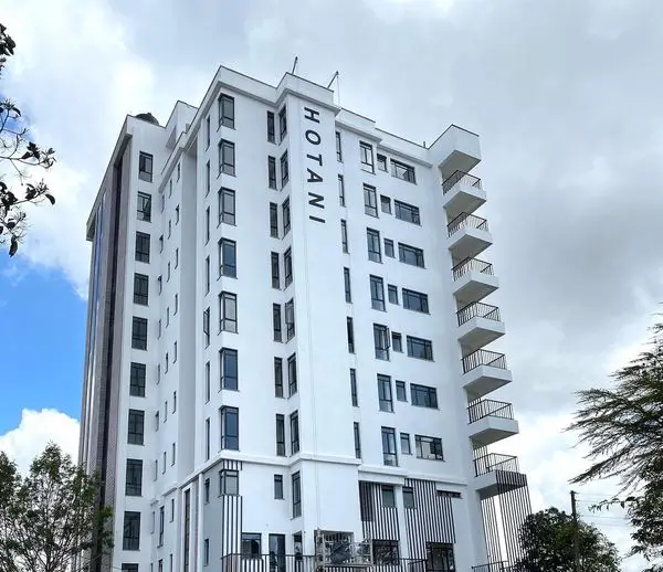 Modern multi-story white residential building with balconies