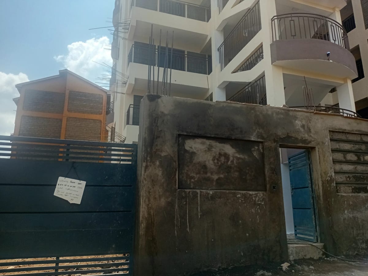 Building compound entrance with gate and adjacent residential tower