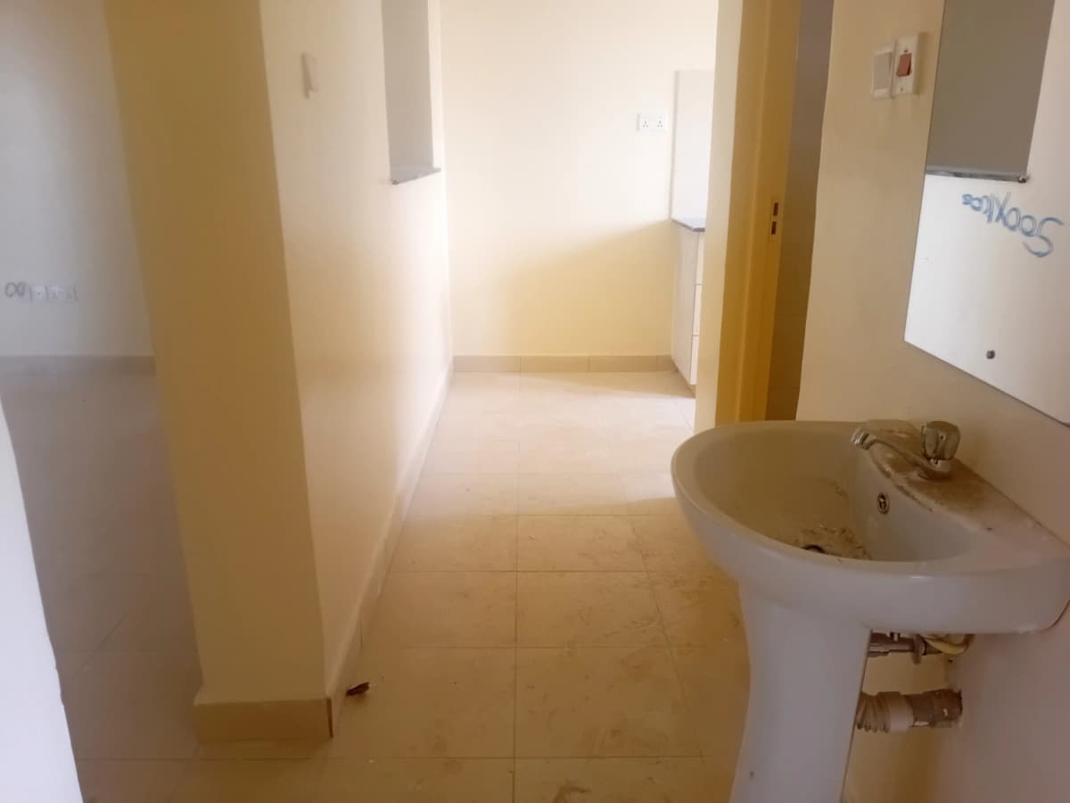 Spacious bathroom with pedestal sink and tiled flooring