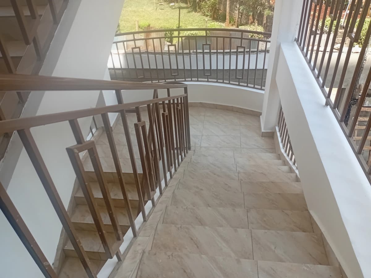 Spacious covered balcony with wooden railings and garden view