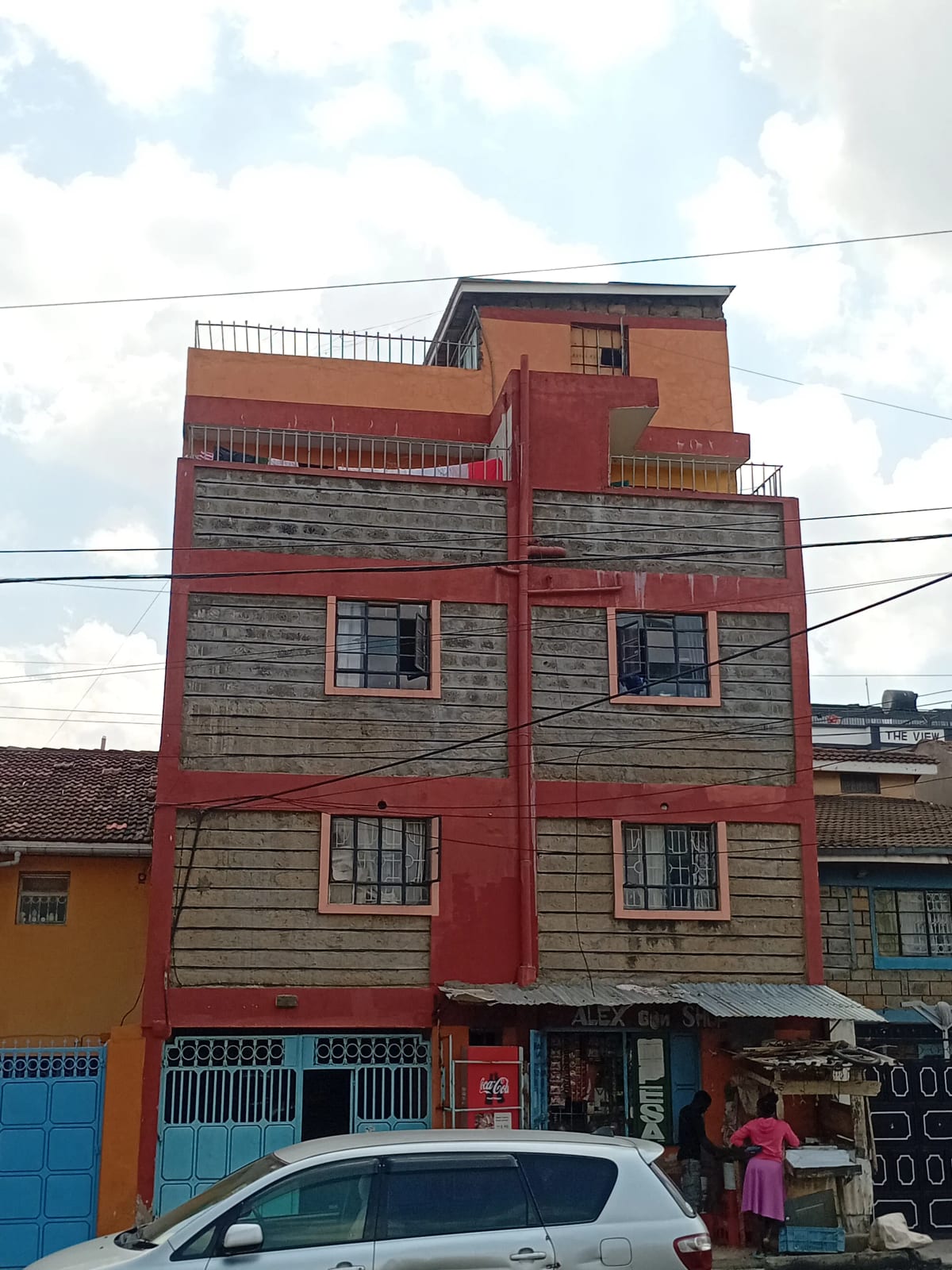 Multi-story residential building facade with red and stone detailing