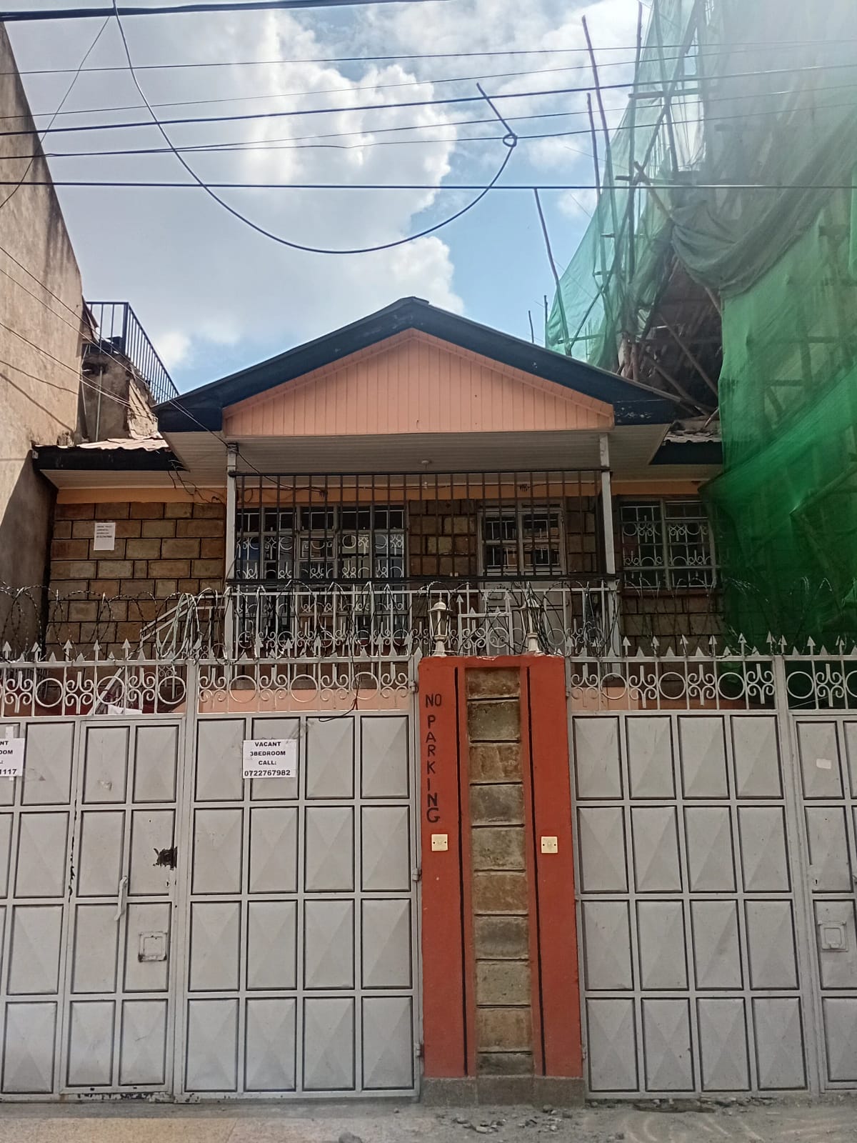 Residential property facade with metal gate and compound entrance