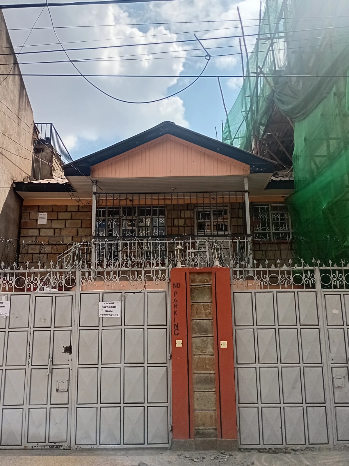 Residential property facade with metal gate and compound entrance
