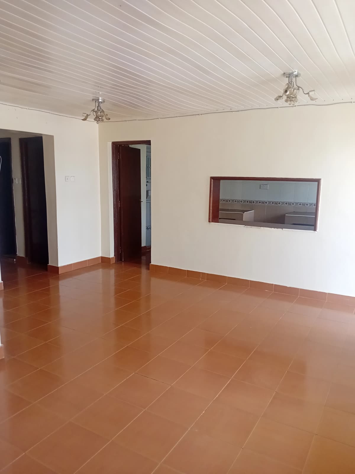 Spacious empty living room with terracotta tile flooring